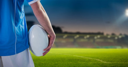 Image of falling covid 19 cells over american football player. Global covid 19 pandemic concept, digital generated image.の写真素材