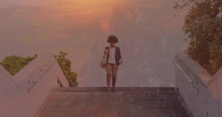 Image of silhouette of reindeer over biracial woman reading map against winter landscape. Sports fitness and technology concept.の写真素材