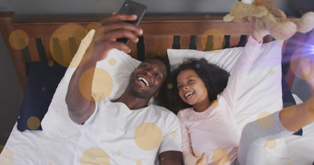 Image of light spots over african american man and his daughter taking selfies. Family, free time...