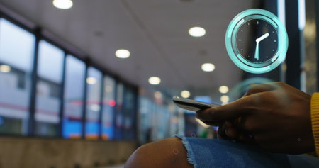 Image of clock moving over african american businesswoman using smartphone. global business and...
