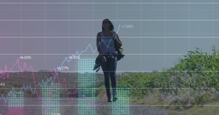 Image of financial data processing over biracial woman walking on street. Global business, finances and digital interface concept digitally generated image.の写真素材