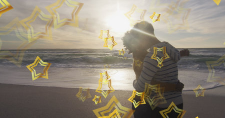 Image of stars over biracial couple at beach. Christmas, celebration and digital interface concept...