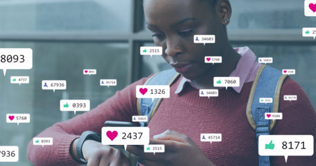 Image of social media icons with growing numbers over african american woman using smartphone. Global social media, technology and digital interface concept digitally generated image.の写真素材