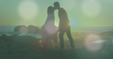 Image of glowing spots over diverse couple kissing. Lifestyle and free time concept digitally generated image.の写真素材