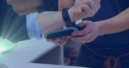 Image of light spots over caucasian man paying with smartwatch. Global business and digital interface concept digitally generated image.の写真素材