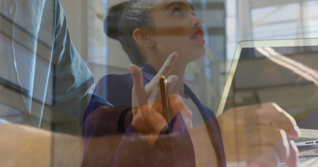 Image of biracial businesswoman over hands using laptop. Global business and digital interface concept digitally generated image.の写真素材