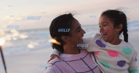 Image of holly texts over biracial mother with daughter at beach. Christmas, celebration and digital interface concept digitally generated image.の写真素材
