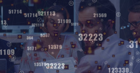 Image of financial data and icons over diverse businesspeople working in office. Global business, finance, economy and technology concept digitally generated image.の写真素材