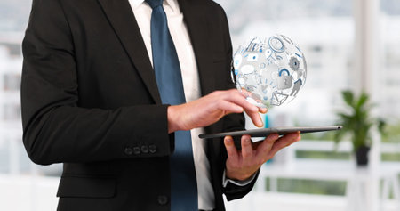 Image of a globe, icons and connection network spinning while a young Caucasian businessman is using a tablet 4kの写真素材
