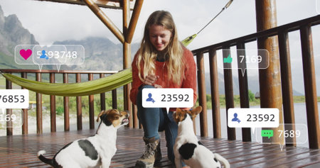 Image of social media text and icons over caucasian woman with dogs on terrace. Global social media, digital interface, computing and data processing concept digitally generated image.