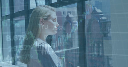 Image of financial data processing over caucasian businesswoman in office. Global business, finance, computing and data processing concept digitally generated image.の写真素材