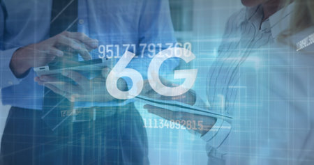 Image of changing numbers and 6g over hands of caucasian businesspeople using tablets. Business, network, communication and technology concept digitally generated image.の写真素材