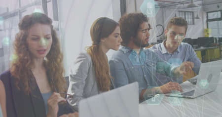 Image of network of connections with icons over diverse female and male coworkers in office....