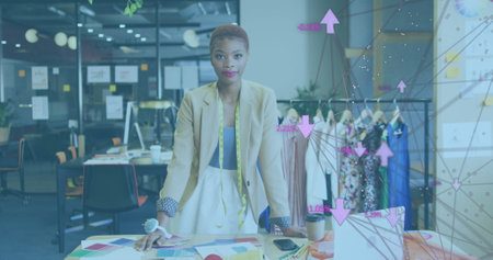 Image of network of connections with icons over african american businesswoman at office. Global business, finances and digital interface concept, digitally generated image.の写真素材