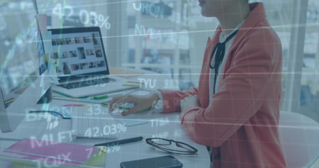 Image of financial data processing over businesswoman using computer. Global business, finance, computing and data processing concept digitally generated image.の写真素材