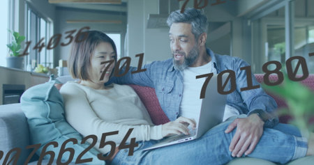 Image of data processing over diverse couple using laptop. Global business and digital interface...