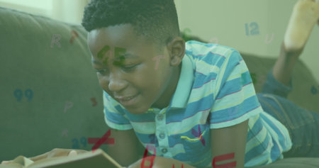 Image of letters and numbers over african american boy reading. Global education, learning and data processing concept digitally generated image.の写真素材