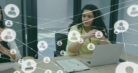 Image of network of connections with people icons over diverse business people in office. Global finance, business, connections, computing and data processing concept digitally generated image.の写真素材