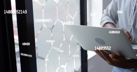 Image of data processing over african american businessman using laptop in office. Global business,...