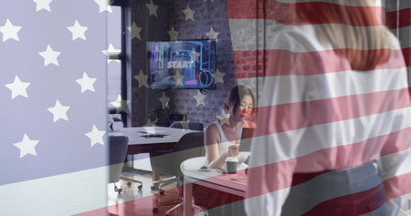 American flag image over businesswoman working at desk in modern office. USA, patriotism, corporate, professional, technology, entrepreneurの写真素材