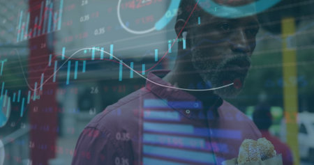 Image of financial data processing over african american man eating sandwich in city. Global finance, business, connections, computing and data processing concept digitally generated image.の写真素材