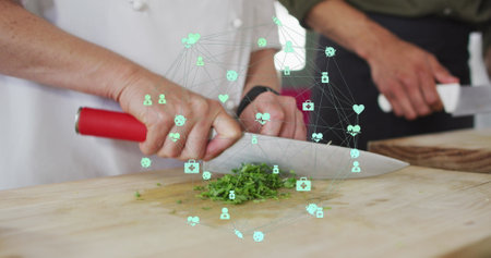 Image of network of connections with icons over diverse people chopping vegetables. Global connections and digital interface concept digitally generated image.の写真素材