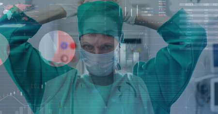 Image of statistics and data processing over caucasian female surgeon. Global medicine, connections, computing and data processing concept digitally generated image.の写真素材