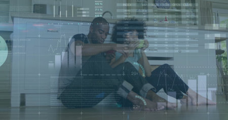 Image of data processing over diverse couple sitting on kitchen floor drinking tea. Global...