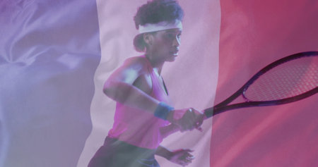 Image of flag of france over african american female tennis player with tennis racket. Sports, competition and active lifestyle concept digitally generated image.の写真素材