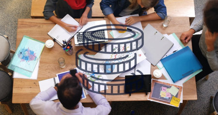 Film reel image over group of people collaborating at desk with documents. Teamwork, collaboration, brainstorming, business, strategy, workplaceの写真素材