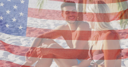 Image of american flag waving over smiling couple in love on beach. usa patriotism and democracy concept digitally generated image.の写真素材