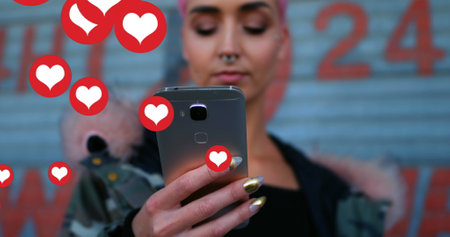 Image of falling social media icons over women using smartphone. social media and communication concept digitally generated image.の写真素材