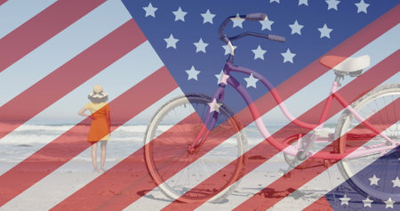 Image of american flag revealing statue of liberty and woman walking on beach. usa patriotism, celebration and democracy concept digitally generated image.の写真素材