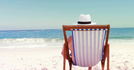 Senior Caucasian man relaxes on a beach chair, with copy space. His tranquil moment captures the essence of a serene beachside retreat.の写真素材