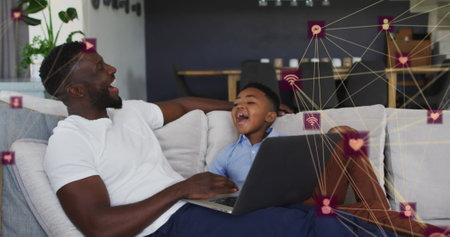 Image of network of connections over happy african american father and son using laptop. family,...