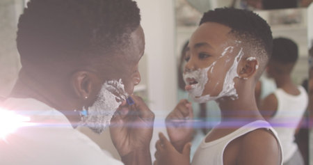 Image of lights over happy african american father and son shaving beards. family, togetherness, spending quality time concept digitally generated image.の写真素材