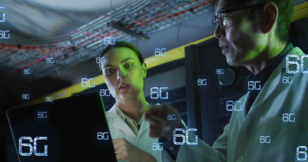 Image of falling 6g text over diverse couple of server room workers. Cloud computing concept concept...