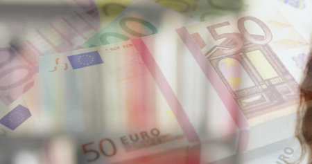 Image of Euro bills over Caucasian woman wearing face mask. Coronavirus Covid-19 pandemic concept digital compositeの写真素材