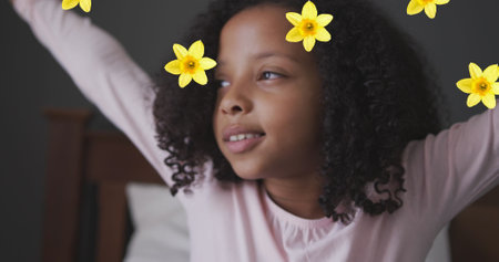 Image of flowers over african american girl waking up. family life and childhood concept digitally generated image.の写真素材