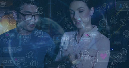 Image of social media icons over diverse couple of server room workers. Cloud computing concept...