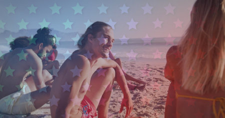 Multiple blinking stars against group of friends sitting on the beach. american independence patriotic holiday conceptの写真素材