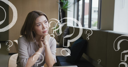 Image of question marks over asian businesswoman thinking. global networks, business, data processing and digital interface concept digitally generated image.の写真素材