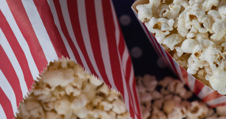 Image of boxes of popcorn over white spots. national popcorn day and celebration concept digitally generated image.の写真素材