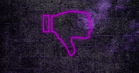 Composition of purple neon thumbs down icon on brick wall. Social media, communication and digital interface concept digitally generated image.の写真素材