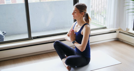 Beautiful woman performing yoga at home 4kの写真素材