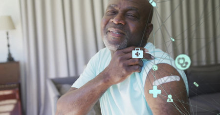 Image of network of connections with icons over senior african american man. Global medicine, healthcare, connections and digital interface concept digitally generated image.の写真素材