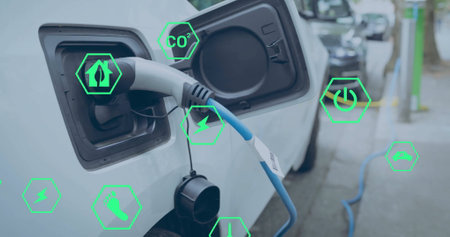 Image of eco icons over electric car being charged. Global green energy, environment, connections, computing and data processing concept digitally generated image.の写真素材