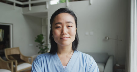 Portrait of happy asian female nurse at work in hospital, smiling to camera. medicine, health and healthcare services.の写真素材