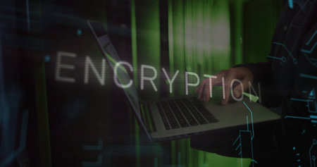 Image of encryption text over caucasian man using laptop in server room. Technology and digital interface concept digitally generated image.の写真素材