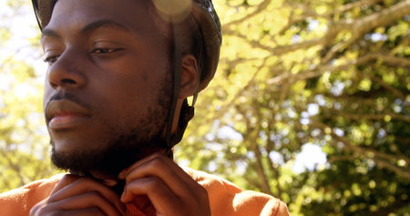 Close up of man is fastening his bike helmet on a parkの写真素材